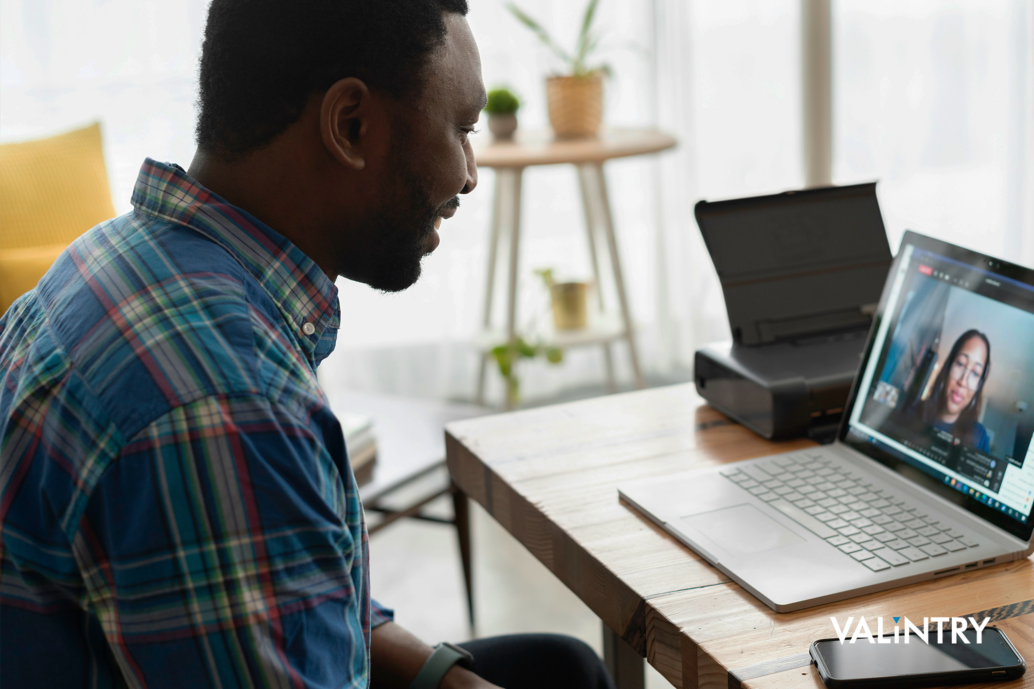 A man interviewing remotely with an IT staffing recruiter at VALiNTRY for an IT job